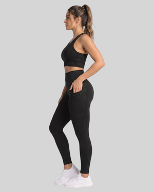 Black high-waisted leggings with functional side pockets from Proven Sportswear, shown on a model.
