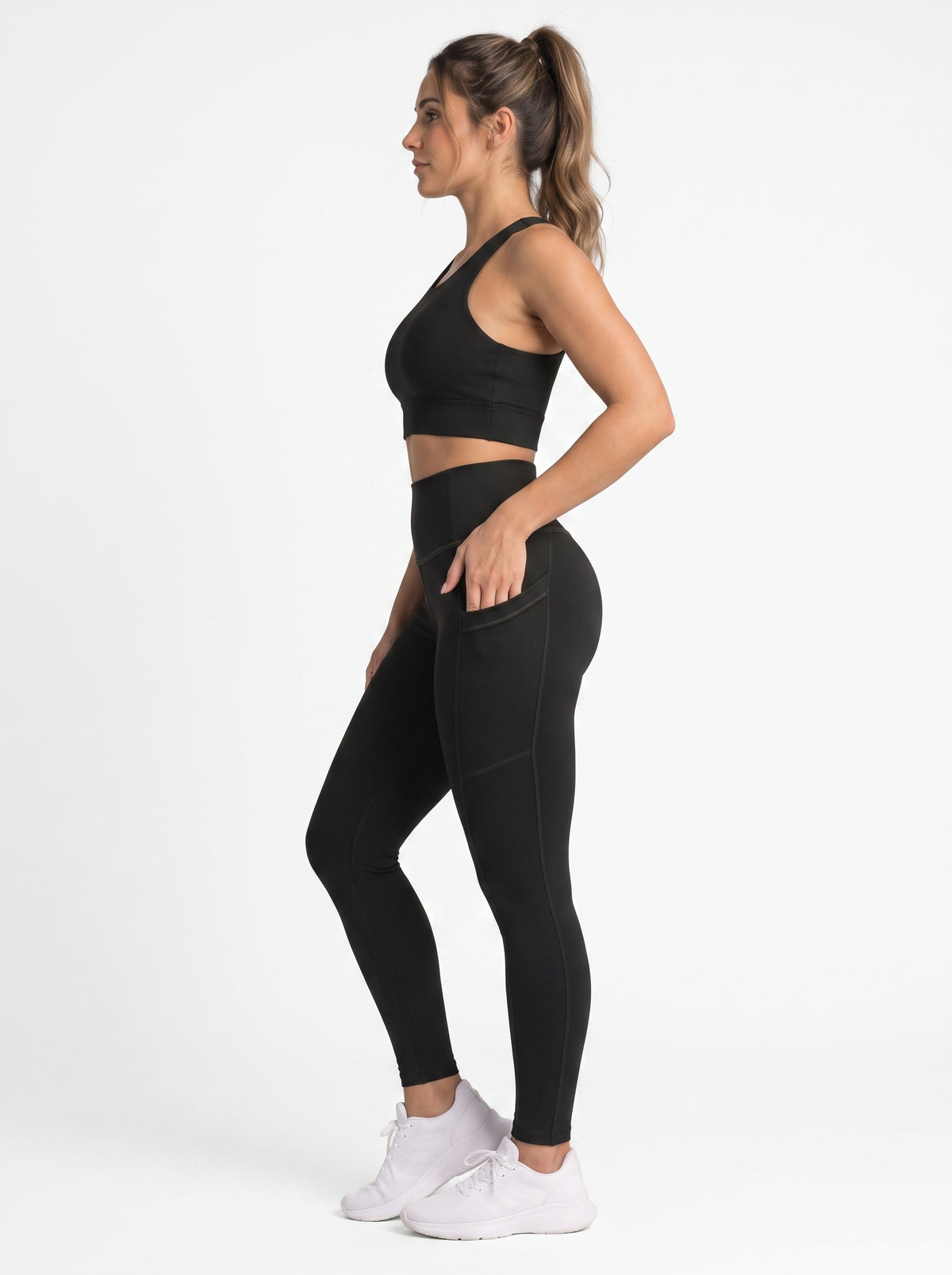 Black high-waisted leggings with functional side pockets from Proven Sportswear, shown on a model.