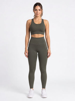 Olive brown high-waisted leggings with front pockets from Proven Sportswear, shown on a model against a neutral background.